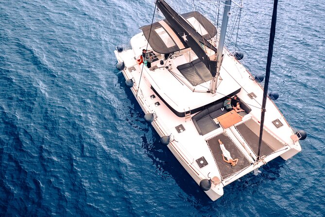 Half Day Premium Catamaran Cruise in Santorini including Oia - Red Beach swim stop: a surreal splash of color