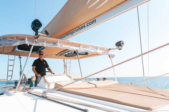 Luxury Santorini Catamaran Cruise: Lunch, BBQ, Drinks, Transfers - Sailing the Red Beach and White Beach areas from the water