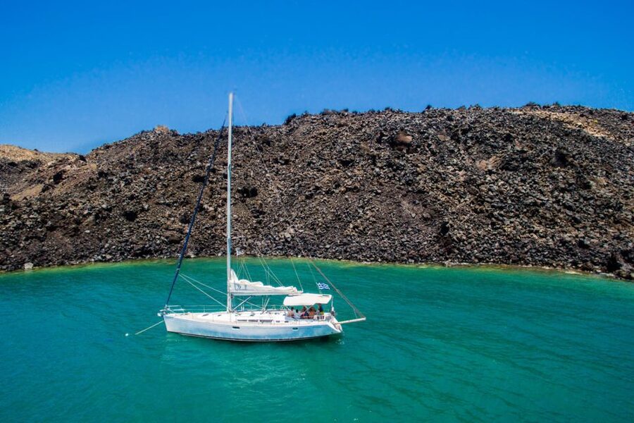 Santorini Caldera: Sunset Sailing Cruise with Meal - Inside the caldera: Indian Rock, the lighthouse, and the Akrotiri angle