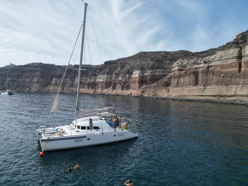 Santorini: Catamaran Cruise with Greek BBQ and Drinks - Red Beach swim and snorkeling: the red rocks are the whole point
