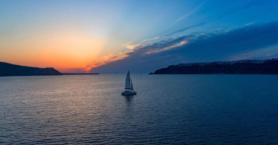 Santorini: Sunset Cruise with Swim Stops, Dinner, and Drinks - White Beach, Black Mountain Beach, and the Venetian lighthouse from the sea